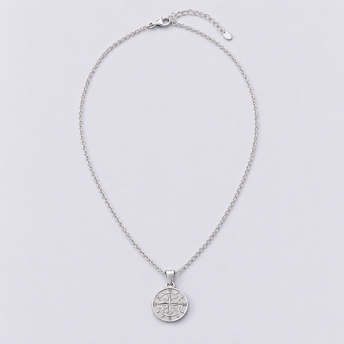 White gold compass necklace full length flat lay